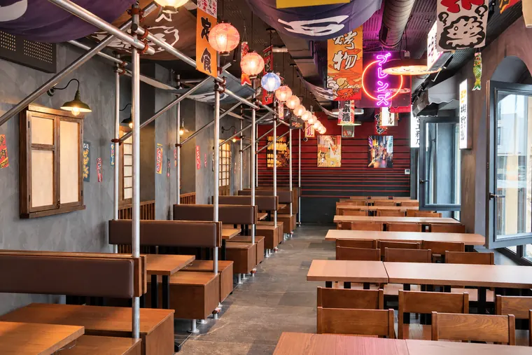 La grande salle : box, tables en bois et baies vitrées